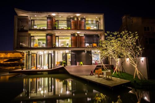 a building with a pool in front of it at night at One Piece B&B in Dongshan