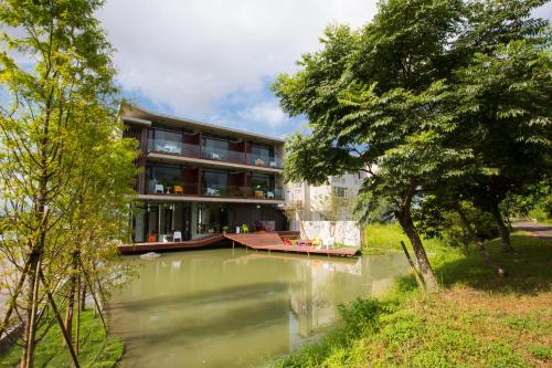 a building with a lake in front of it at One Piece B&B in Dongshan