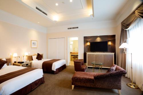 a hotel room with two beds and a flat screen tv at Sapporo Excel Hotel Tokyu in Sapporo