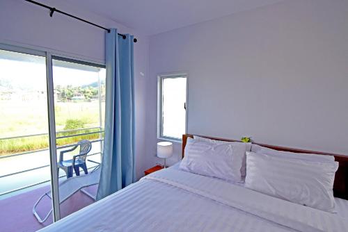 1 dormitorio con cama y ventana grande en Anissa Resort Koh Yao Yai, en Ko Yao Yai