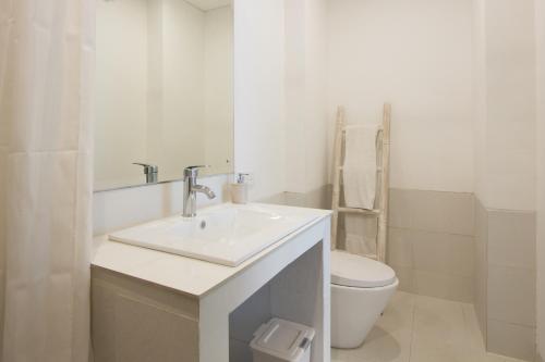 Un baño blanco con lavabo e inodoro. en Soraya Apartment Seminyak, en Seminyak