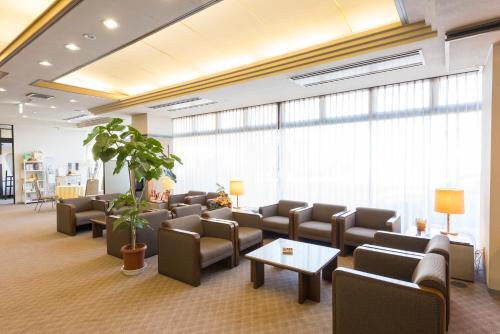 a waiting room with couches and chairs and a plant at Sky Hotel Namerikawa in Namerikawa