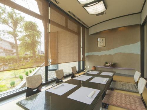 a conference room with tables and chairs and a large window at Sky Hotel Namerikawa in Namerikawa