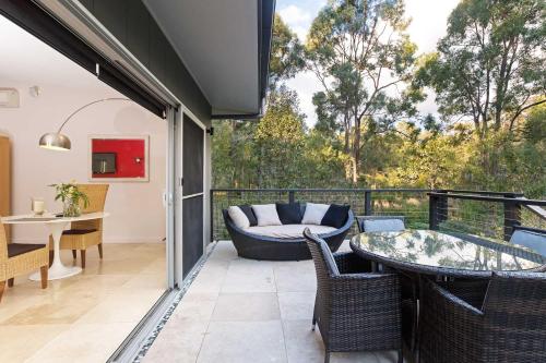 a patio with a couch and a table and chairs at Deja Vu Estate in Pokolbin
