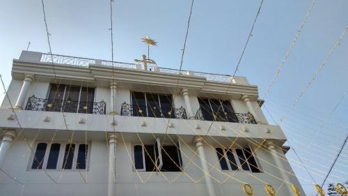 a white building with a balcony on top of it at Georgian Inn in Kolkata