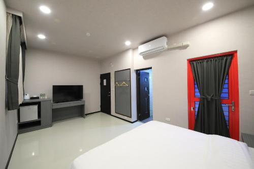 a bedroom with a bed and a tv at 花蓮亮君經典民宿1館加2館民宿-東大門夜市-電梯包棟Bright King Homestay in Hualien City