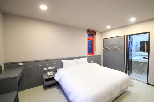 a bedroom with a large white bed and a window at 花蓮亮君經典民宿1館加2館民宿-東大門夜市-電梯包棟Bright King Homestay in Hualien City