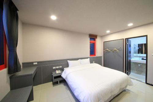 a bedroom with a large white bed and a window at 花蓮亮君經典民宿1館加2館民宿-東大門夜市-電梯包棟Bright King Homestay in Hualien City