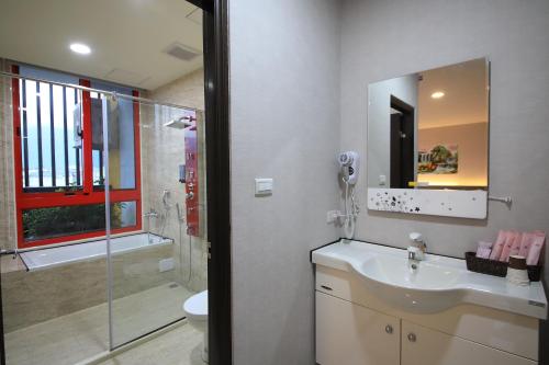 a bathroom with a sink and a shower and a mirror at 花蓮亮君經典民宿1館加2館民宿-東大門夜市-電梯包棟Bright King Homestay in Hualien City