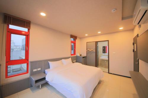 a bedroom with a large white bed and a window at 花蓮亮君經典民宿1館加2館民宿-東大門夜市-電梯包棟Bright King Homestay in Hualien City
