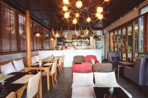 a restaurant with tables and chairs and a bar at Tapae Gate Villa in Chiang Mai