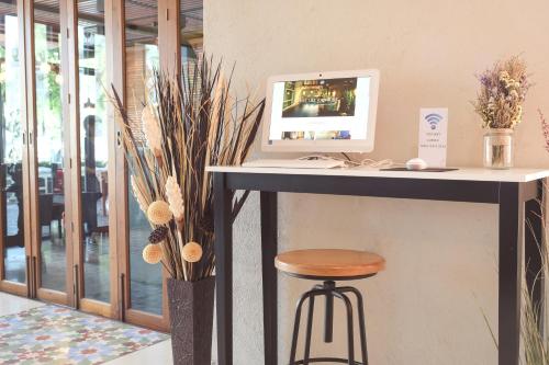a desk with a computer and a stool at Tapae Gate Villa in Chiang Mai