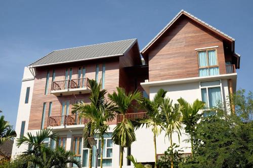a building with palm trees in front of it at Tapae Gate Villa in Chiang Mai