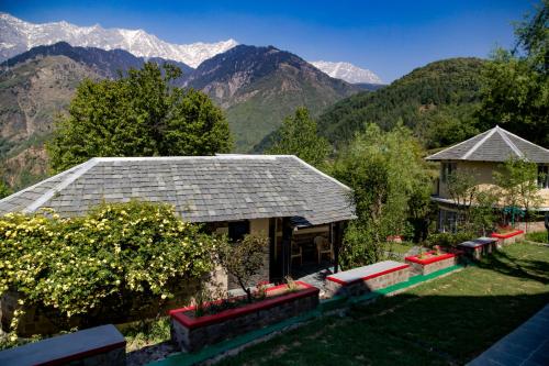 a house with a view of the mountains at Hotel Udechee Huts, McLeod Ganj in McLeod Ganj