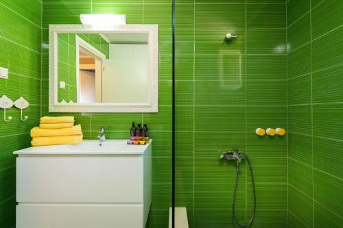 un bagno verde con lavandino e doccia di Casa Arokaria a Pendarianá