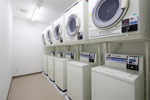 a row of washers and dryers in a laundry room at Value The Hotel Naraha Kido Ekimae in Kido