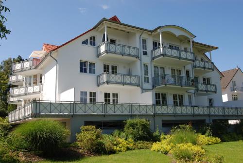 ein großes weißes Gebäude mit Balkonen darauf in der Unterkunft Villa Vilmblick - Wohnung 23 mit Meerblick-Balkon in Lauterbach
