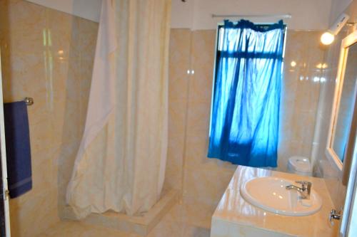 a bathroom with a sink and a shower at Hotel Breeta's Garden in Ginigathena