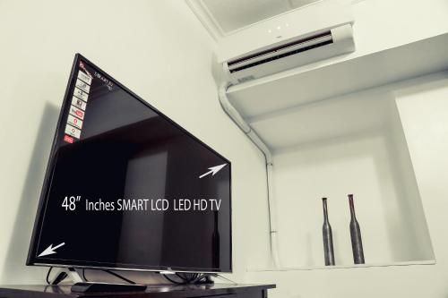 a flat screen tv sitting on top of a table at 1014 West Insula Suites by AYS in Manila