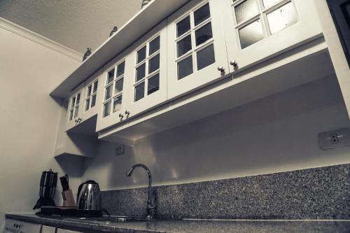 a kitchen with a shelf above a sink at 1014 West Insula Suites by AYS in Manila