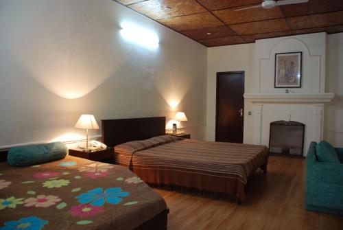 a hotel room with two beds and a fireplace at Alasia Hotel in Kasauli