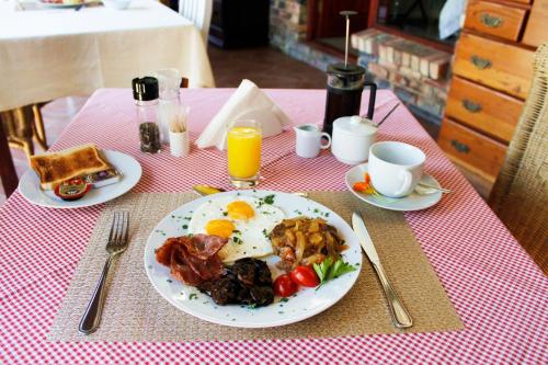 a table with a plate of breakfast food on it at Amani Guest Lodge in Port Elizabeth