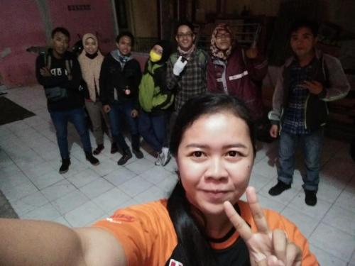 a woman giving the peace sign with a group of people at Homestay Lidiya in Banyuwangi