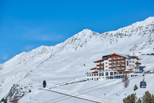 a building on a snow covered mountain with a ski lift at Alpenhotel Laurin in Hochgurgl