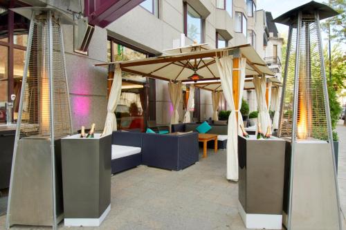 a patio with tables and umbrellas in front of a building at Novotel Montreal Center in Montréal