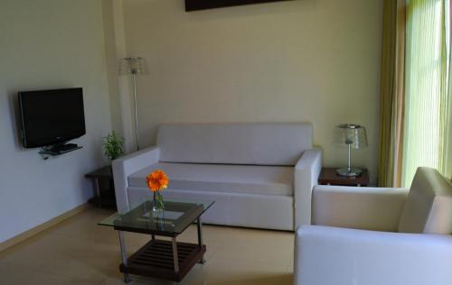 a living room with a white couch and a table at The Waterfront Shaw Lavasa in Lavasa