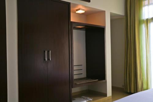a black cabinet with a mirror in a bedroom at The Waterfront Shaw Lavasa in Lavasa