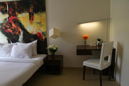 a bedroom with a bed and a desk with a chair at The Waterfront Shaw Lavasa in Lavasa