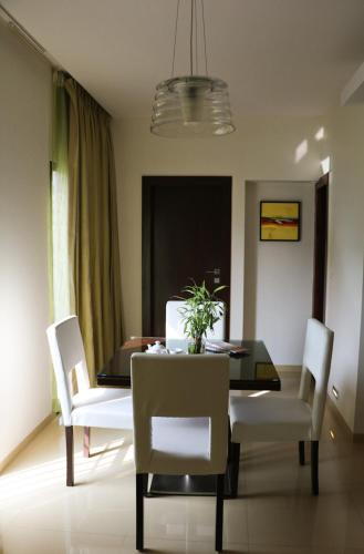 a dining room with a table and white chairs at The Waterfront Shaw Lavasa in Lavasa