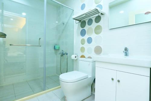 a bathroom with a shower and a toilet and a sink at 奇遇85民宿 in Ji'an