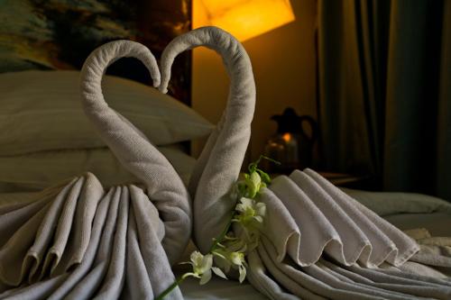 two towels shaped like swans sitting on a bed at The Waterfront Shaw Lavasa in Lavasa