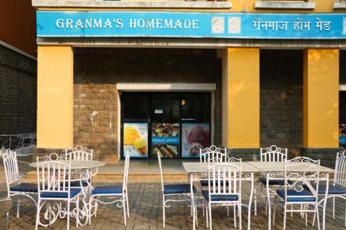 a table and chairs in front of a restaurant at The Waterfront Shaw Lavasa in Lavasa
