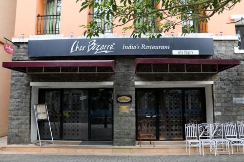 a store with tables and chairs outside of a building at The Waterfront Shaw Lavasa in Lavasa