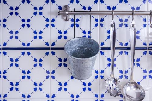 a blue and white tiled bathroom with a bucket and spoons at Le Conchiglie in Marettimo