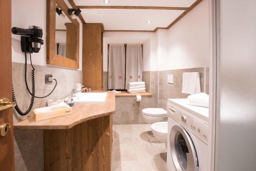 een badkamer met een wastafel en een wasmachine bij Apartments Bucaneve in Breuil-Cervinia