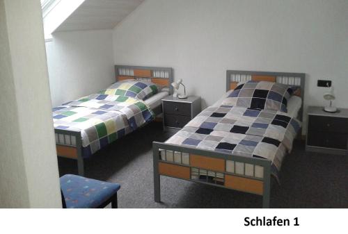 2 camas en una habitación con 2 camas en Ferienwohnung Bäumener, en Hilchenbach
