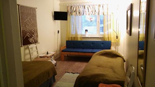 uma sala de estar com um sofá azul e uma janela em Matkustajakoti Kuutamo Guesthouse em Suomussalmi