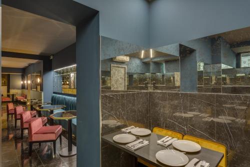 a restaurant with tables and chairs and a bar at Otivm Hotel in Rome