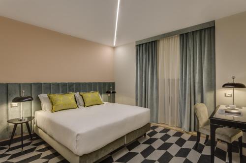 a hotel room with a bed and a desk and a bed sidx sidx at Otivm Hotel in Rome