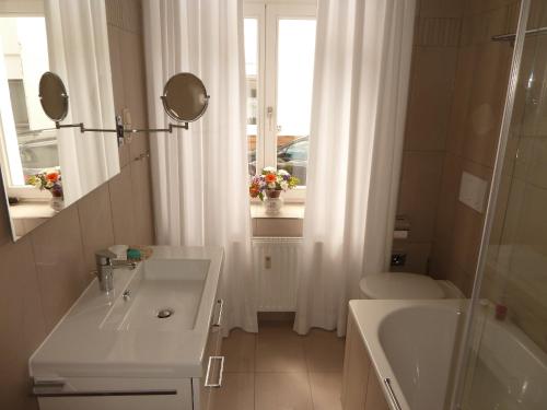 ein Badezimmer mit einem Waschbecken, einer Badewanne und einer Dusche in der Unterkunft Appartement Fischersfritze in Göhren