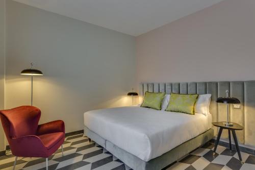 a bedroom with a bed and a chair at Otivm Hotel in Rome