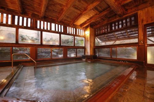 een zwembad in een kamer met ramen bij Matsukaneya Annex in Zao Onsen
