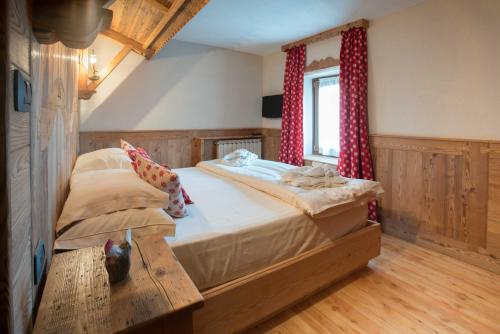 een slaapkamer met een groot bed en een houten tafel bij Apartments Bucaneve in Breuil-Cervinia