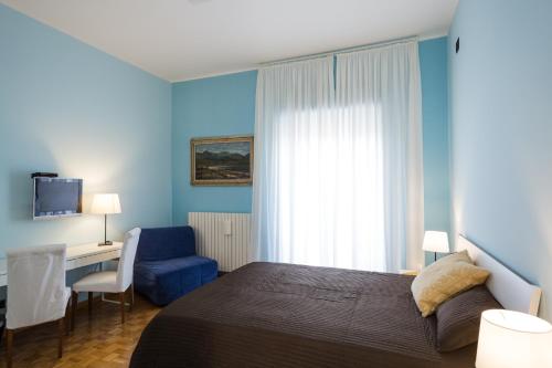 a bedroom with a bed and a desk and a chair at Camere Pallotta in Macerata