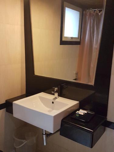 a bathroom with a white sink and a mirror at The Classik Fort in Cochin