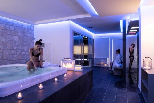 a woman sitting in a bath tub in a bathroom at Relais Madonna di Campagna in Bastia Umbra